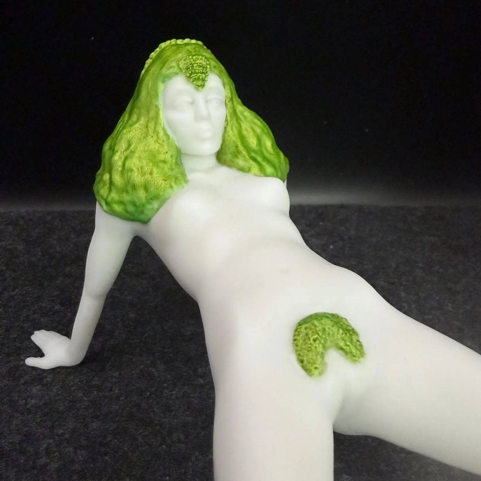 Close-up of a Korova Milk Bar Table showing green hand-painted hair and a white face and body