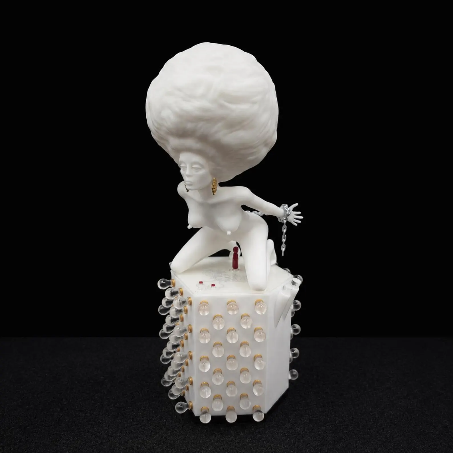 Korova Milk Bar Maid, full view of the white sculpture on its decorated base against a black background